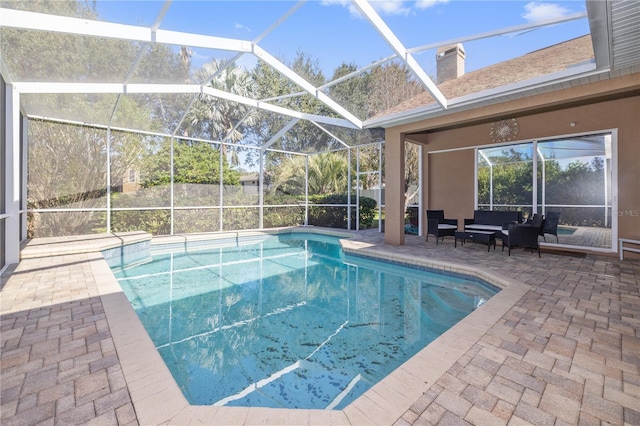 view of pool featuring outdoor lounge area, glass enclosure, and a patio area