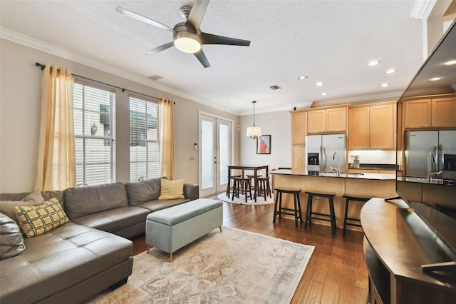 living room featuring french doors, sink, crown molding, a textured ceiling, and dark hardwood / wood-style floors