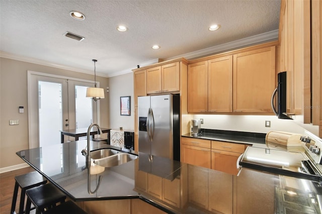 kitchen with appliances with stainless steel finishes, pendant lighting, sink, ornamental molding, and a textured ceiling