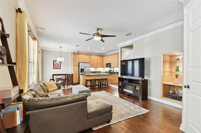 living room with sink, dark hardwood / wood-style flooring, ornamental molding, ceiling fan, and a textured ceiling