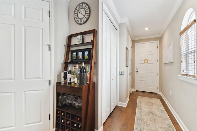 entryway featuring bar, crown molding, and dark wood-type flooring