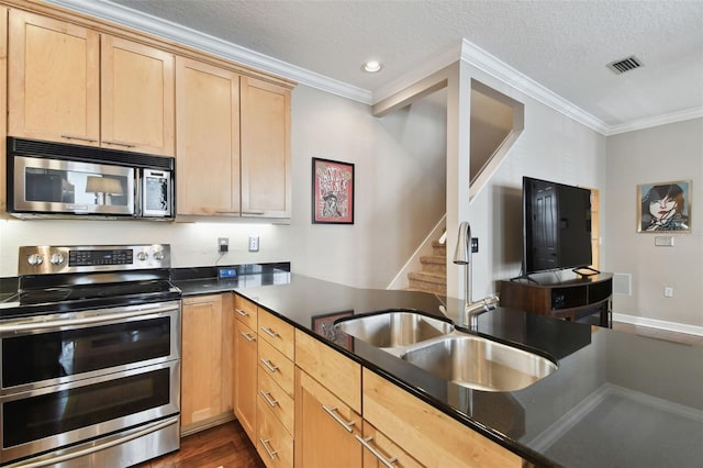 kitchen with ornamental molding, stainless steel appliances, a textured ceiling, and light brown cabinets