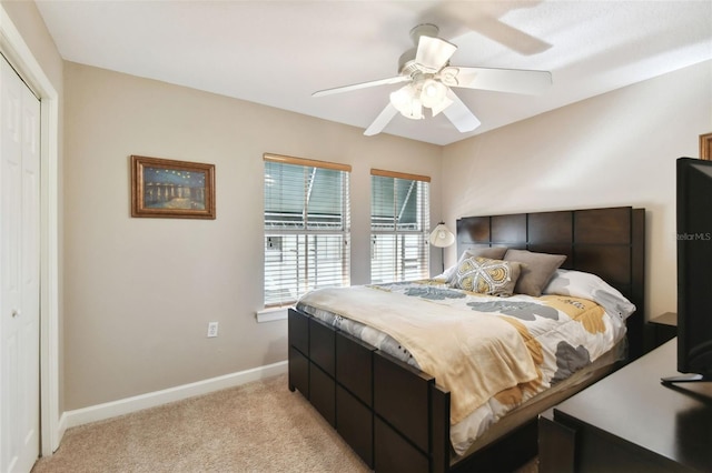 bedroom with light carpet, ceiling fan, and a closet