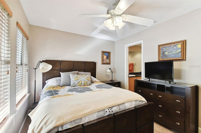 carpeted bedroom with ceiling fan and ensuite bathroom