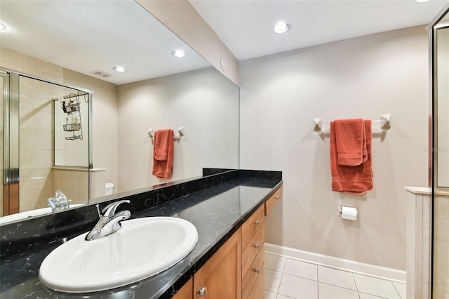 bathroom featuring vanity, a shower with shower door, and tile patterned flooring