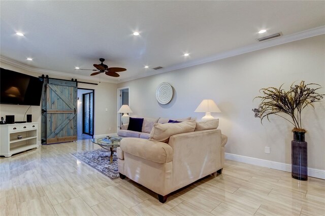 living room with a barn door, ceiling fan, and ornamental molding