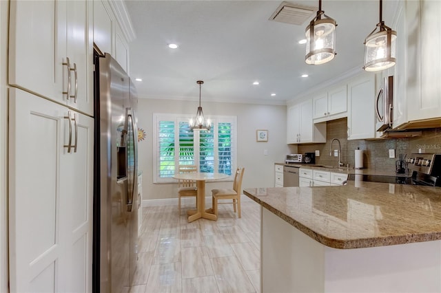 kitchen with white cabinets, decorative light fixtures, kitchen peninsula, and stainless steel appliances