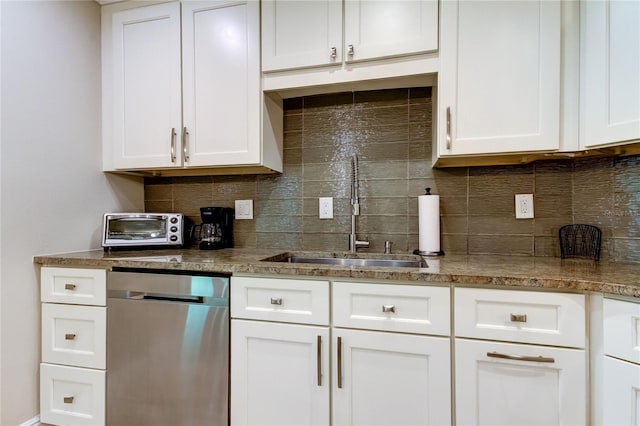 kitchen featuring tasteful backsplash, sink, white cabinets, and stainless steel dishwasher