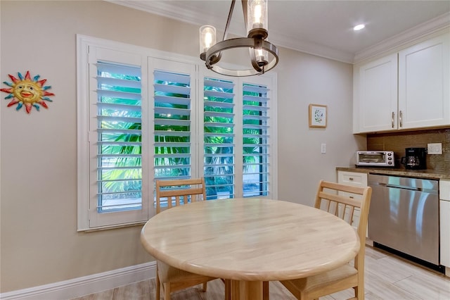 dining room with a notable chandelier, light hardwood / wood-style floors, and ornamental molding