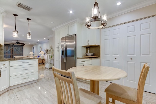 kitchen with pendant lighting, ceiling fan, white cabinets, and stainless steel refrigerator with ice dispenser