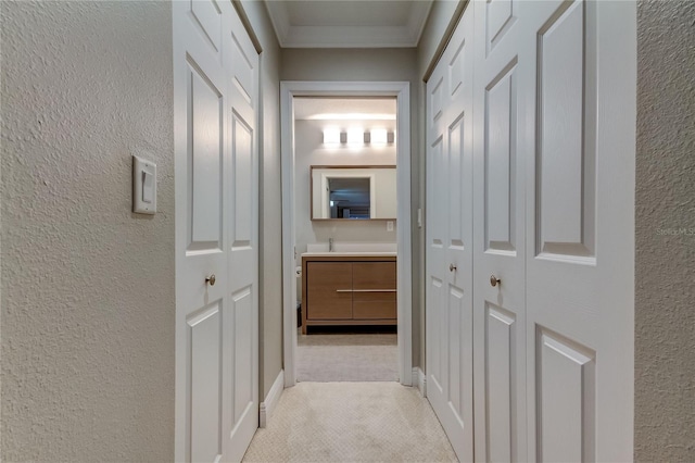 hallway featuring crown molding and light carpet