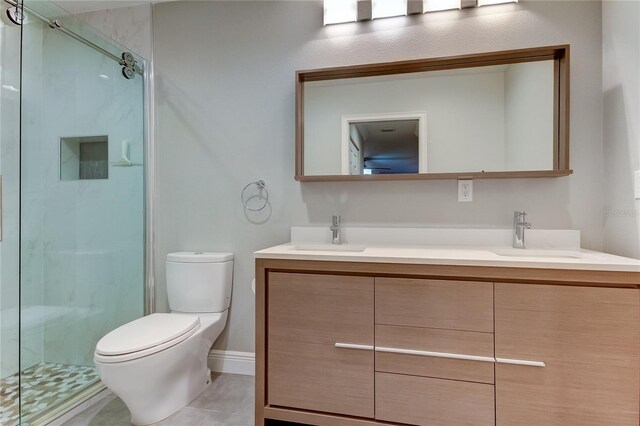 bathroom with tile patterned flooring, vanity, toilet, and an enclosed shower