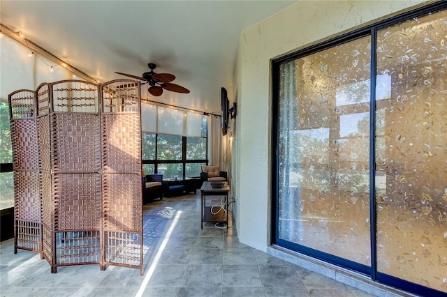 interior space with ceiling fan