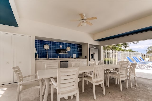 dining space with tile walls and ceiling fan