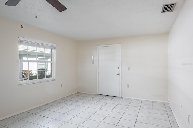 unfurnished room featuring light tile patterned flooring and a textured ceiling