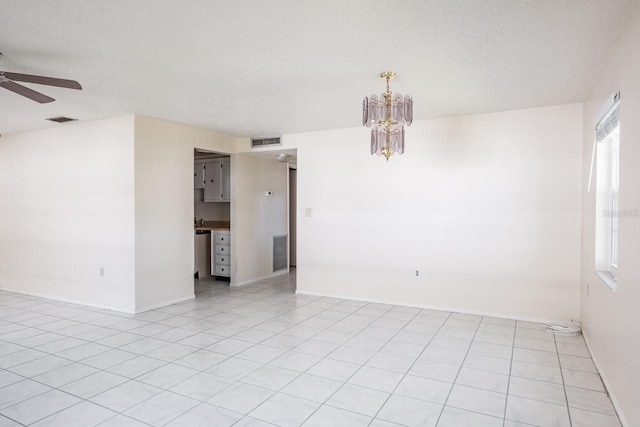 tiled spare room featuring ceiling fan and a textured ceiling