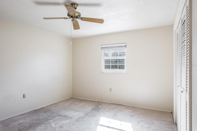 unfurnished bedroom featuring ceiling fan, a closet, light carpet, and a textured ceiling