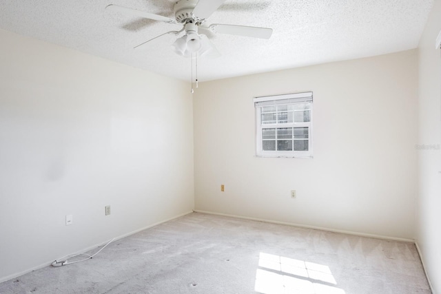 empty room featuring a textured ceiling, light colored carpet, and ceiling fan