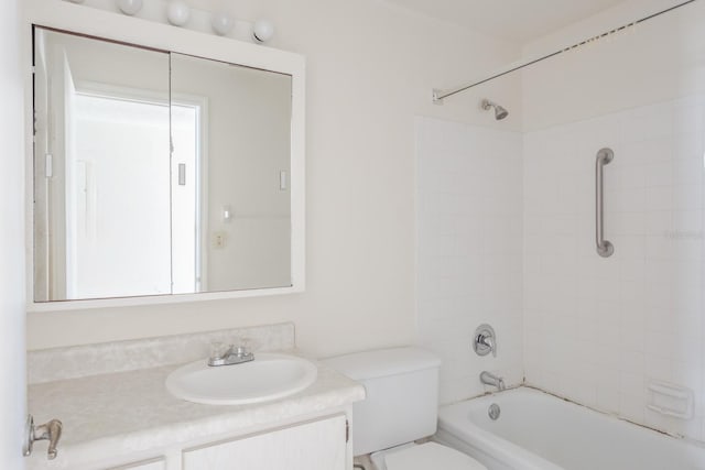 full bathroom featuring vanity, tiled shower / bath combo, and toilet