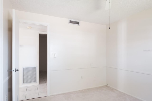 carpeted empty room with a textured ceiling