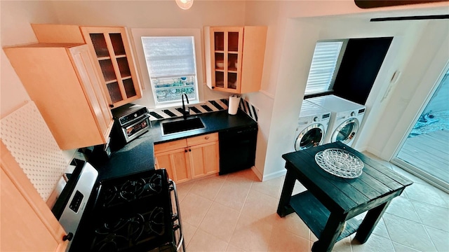 kitchen featuring sink, light brown cabinets, independent washer and dryer, light tile patterned flooring, and black appliances