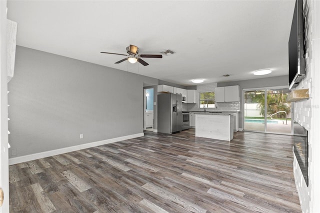 kitchen featuring white cabinetry, a center island, stainless steel appliances, dark hardwood / wood-style floors, and decorative backsplash