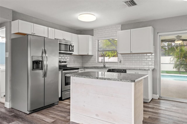 kitchen with hardwood / wood-style flooring, sink, white cabinets, and appliances with stainless steel finishes