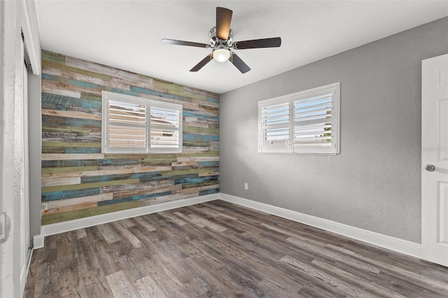 spare room with dark hardwood / wood-style flooring, ceiling fan, and plenty of natural light