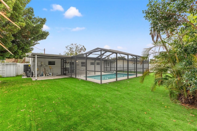 back of house with a lawn, a lanai, a fenced in pool, and a patio