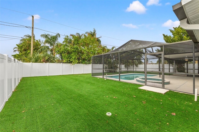 view of yard with a patio, glass enclosure, and a pool with hot tub