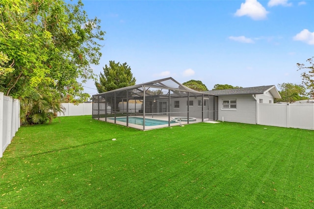 back of property with a lawn, glass enclosure, and a fenced in pool