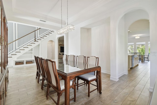 dining area featuring crown molding and an inviting chandelier