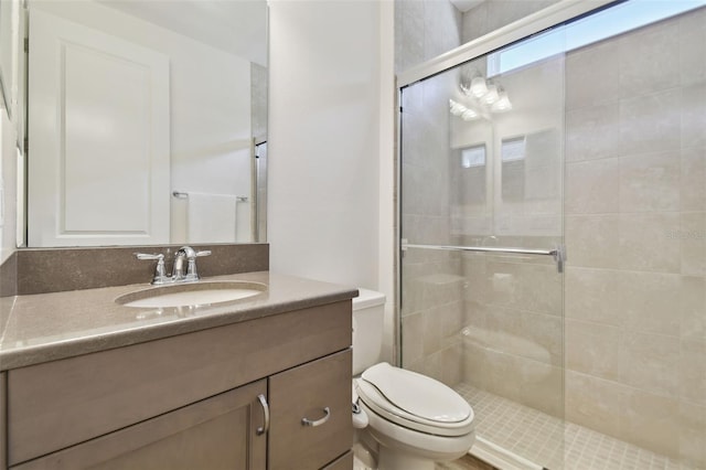 bathroom featuring toilet, vanity, and an enclosed shower