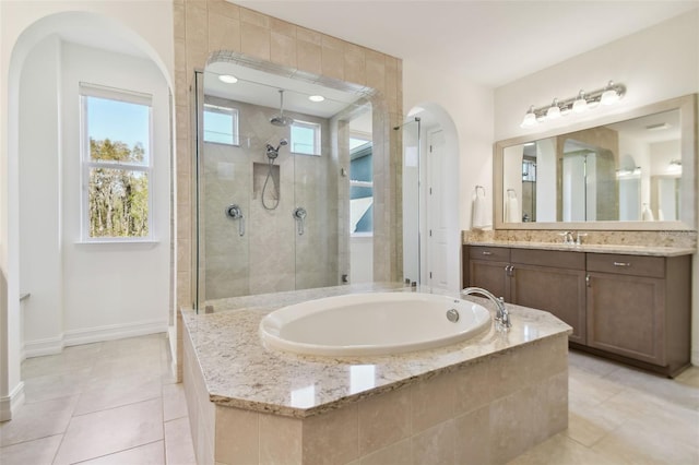 bathroom featuring tile patterned flooring, shower with separate bathtub, and vanity