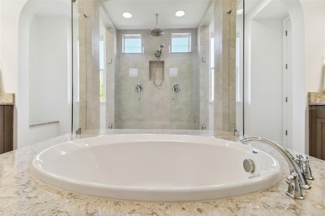 bathroom featuring vanity and plus walk in shower