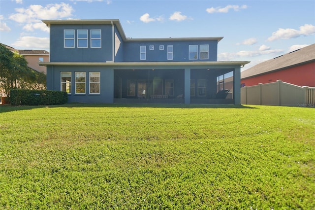 back of house with a sunroom and a lawn