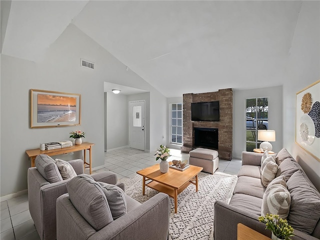 tiled living room featuring high vaulted ceiling and a stone fireplace