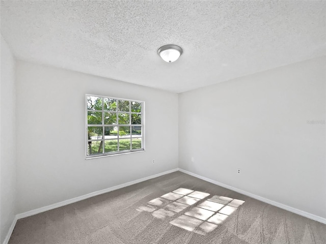 carpeted spare room with a textured ceiling