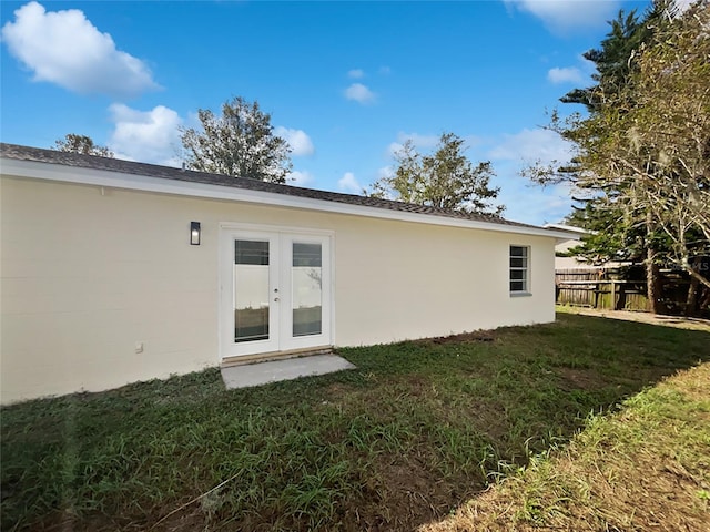 rear view of property featuring a lawn and french doors