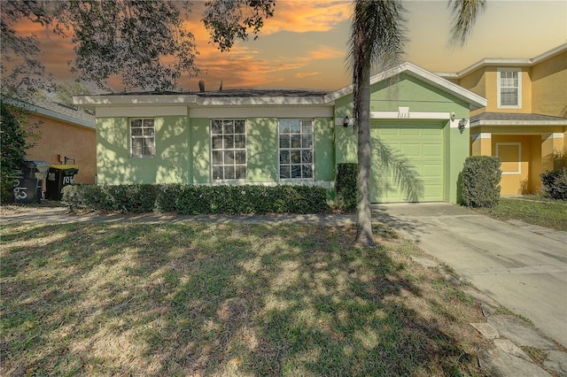 view of front of property featuring a garage and a lawn