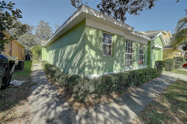 view of home's exterior with a garage and central AC