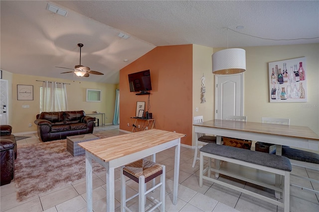 interior space featuring ceiling fan, lofted ceiling, and a textured ceiling