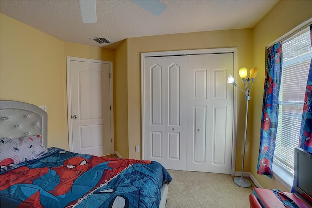 bedroom with multiple windows, a textured ceiling, carpet floors, and ceiling fan