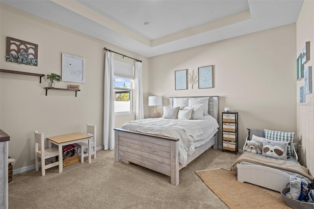 carpeted bedroom featuring a raised ceiling