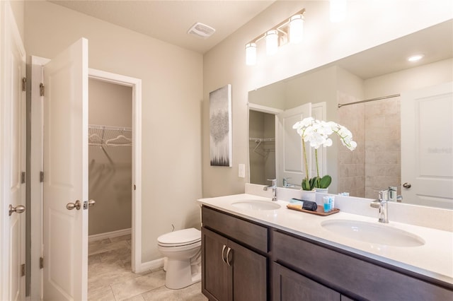 bathroom with toilet, vanity, and tile patterned flooring