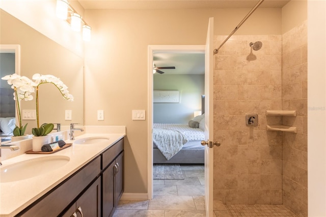 bathroom with vanity, ceiling fan, and tiled shower