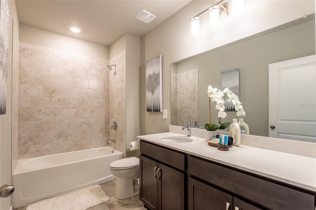 full bathroom featuring toilet, tiled shower / bath combo, tile patterned floors, and vanity