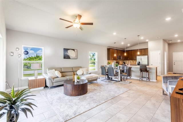 living room with vaulted ceiling, ceiling fan, light tile patterned flooring, and sink