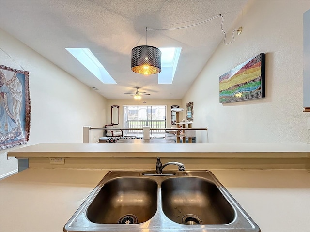 6262 93rd Ter N Unit 3904, Pinellas Park, FL 33782 - kitchen with a skylight, lofted ceiling, decorative light fixtures, a textured ceiling, and light countertops