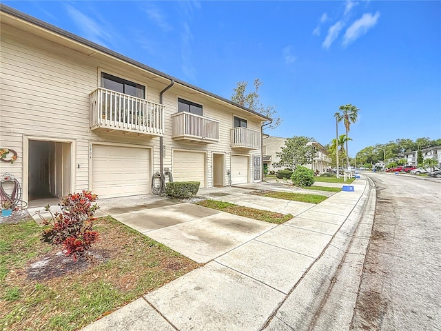 townhome / multi-family property with driveway, an attached garage, and a residential view